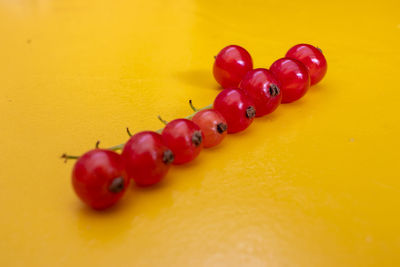 High angle view of strawberries on table against yellow background
