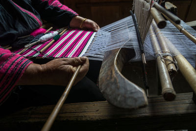 Low section of man working on loom