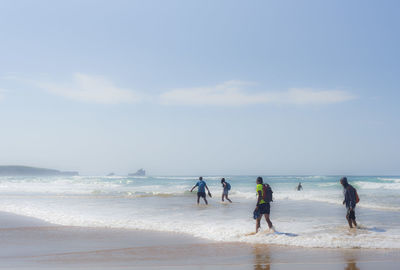 People on beach against sky