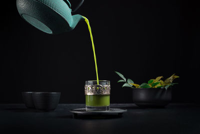 Close-up of potted plant on table against black background