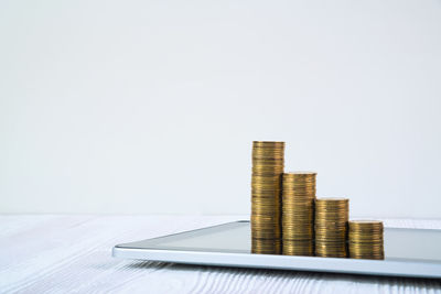 Stack of coins on table against white background