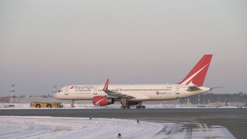 Airplane on airport runway against clear sky