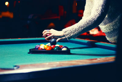 Close-up of hand playing with ball on table