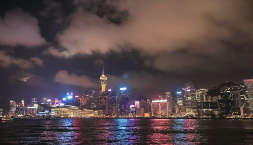 Illuminated buildings in city against sky at night