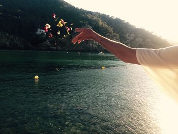 Person throwing flowers in sea