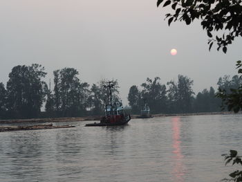 Boats sailing in river against sky