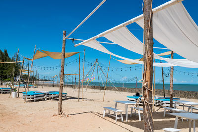 Relax cafe seats on white sand beach in sunny day against blue sky at cha-am, phetchaburi