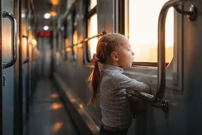 Rear view of girl sitting in train