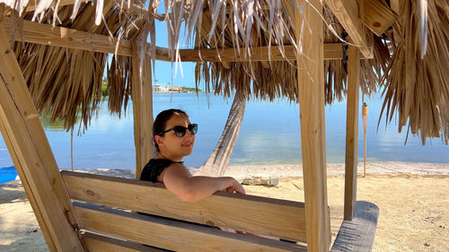 Portrait of woman sitting on hammock at beach