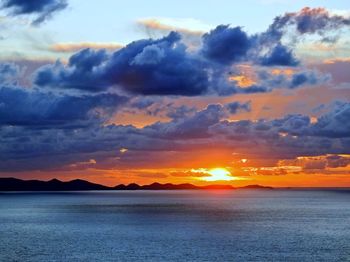 Scenic view of sea against dramatic sky during sunset