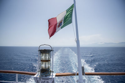Flag on sea against sky