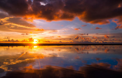 Scenic view of sea against dramatic sky during sunset