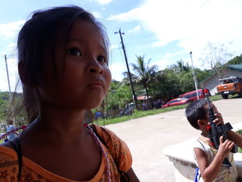 Portrait of girl on road against sky