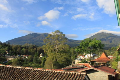 Scenic view of townscape and mountains against sky