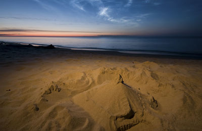 Scenic view of beach against sky during sunset