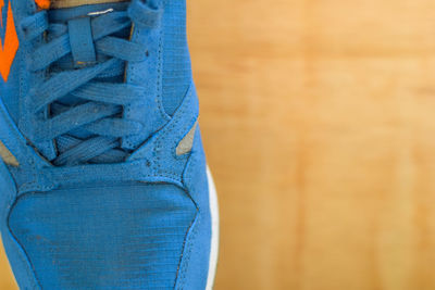 Close-up of blue shoe on hardwood floor