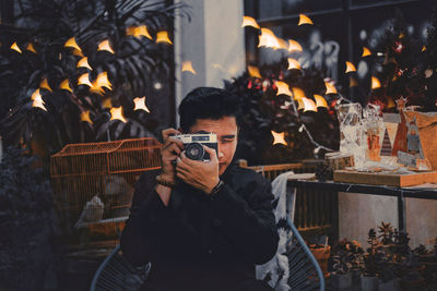 Full length portrait of young man standing against fire