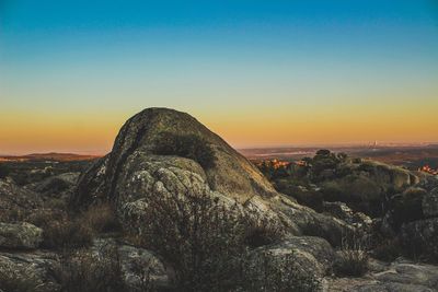 Scenic view of rock against sky during sunset