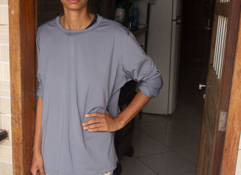 Portrait of young woman standing at home