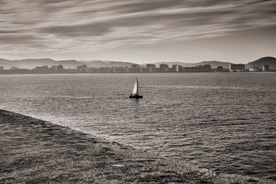 Sailboat sailing on sea against sky