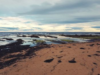 Scenic view of beach against sky during sunset