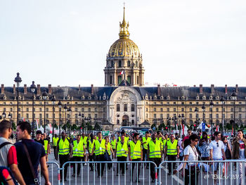 Group of people in front of building against clear sky