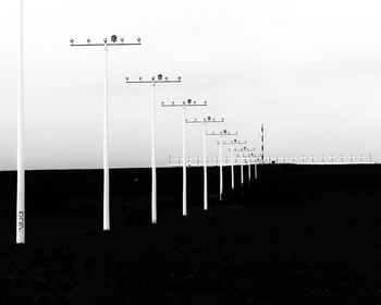 Street lights on field against clear sky