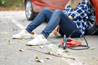 Low section of woman sitting on street