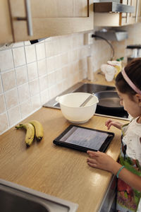 Girl in kitchen using tablet