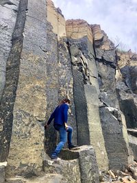 Rear view of woman standing on rock