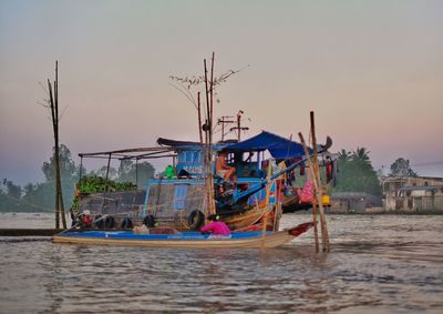 Fishing boats in sea against clear sky