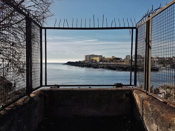 Scenic view of sea by buildings against sky