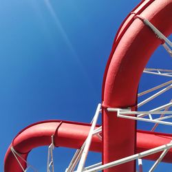 Low angle view of ferris wheel against clear blue sky