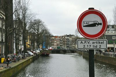 Roadsign against canal along built structures