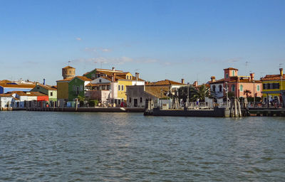 Boats in sea against clear blue sky