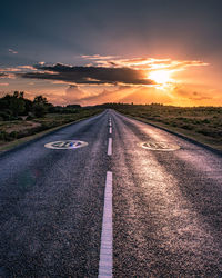 Empty road against sky during sunset