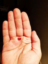 Close-up of human hand against black background