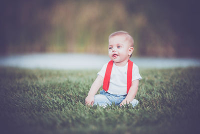 Portrait of cute boy sitting on field