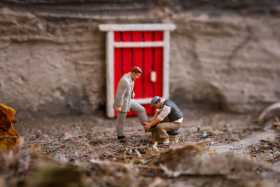 Man and red umbrella on land against building
