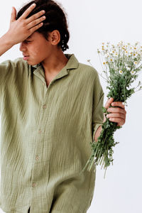 Side view of young woman holding plant