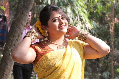 Portrait of smiling beautiful woman wearing yellow sari