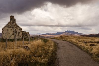 Road amidst field against sky