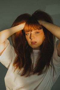 Portrait of young woman against wall