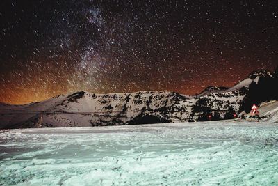 Scenic view of snow covered mountains at night