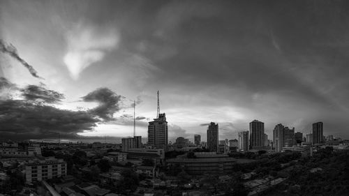 View of cityscape against cloudy sky