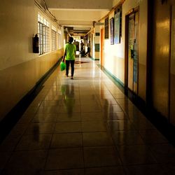 Full length of illuminated people walking in corridor