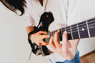 Midsection of man playing guitar