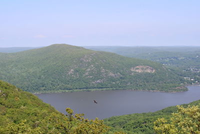 Scenic view of lake by mountains against sky