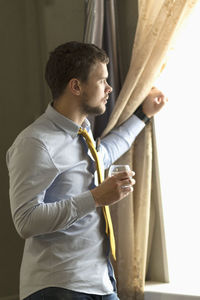 Side view of man looking at camera
