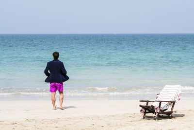 Rear view of woman standing on beach